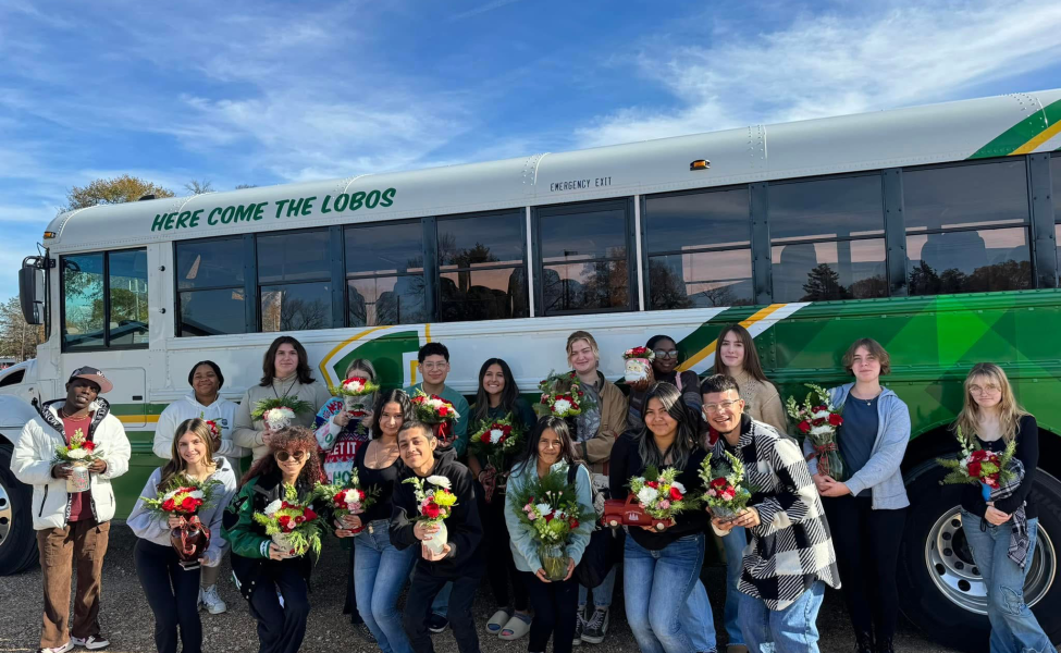 Lobo FFA Floral members stand in front of a district school bus