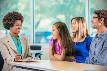 Family signing child up for school.