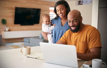 STOCK PHOTO - Happy family working on computer together