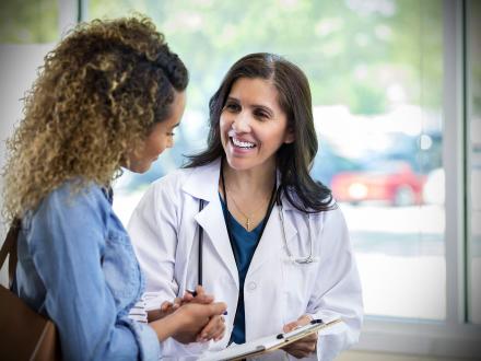 STOCK PHOTO - smiling Doctor talks with teen