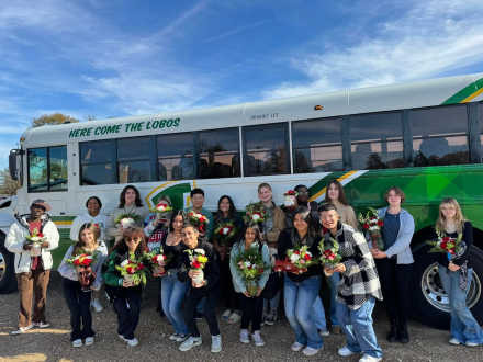 Lobo FFA Floral members stand in front of a district school bus