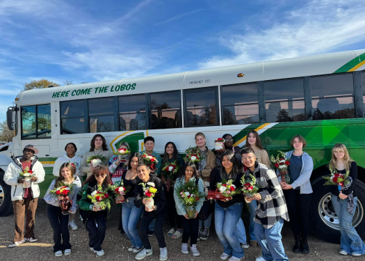 Lobo FFA Floral members stand in front of a district school bus