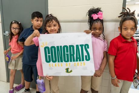 students with a congratulations sign