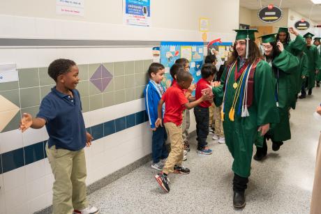 student giving high give to elementary student